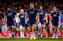 Huw Jones walks behind the Scotland posts as Wales celebrate a second half try